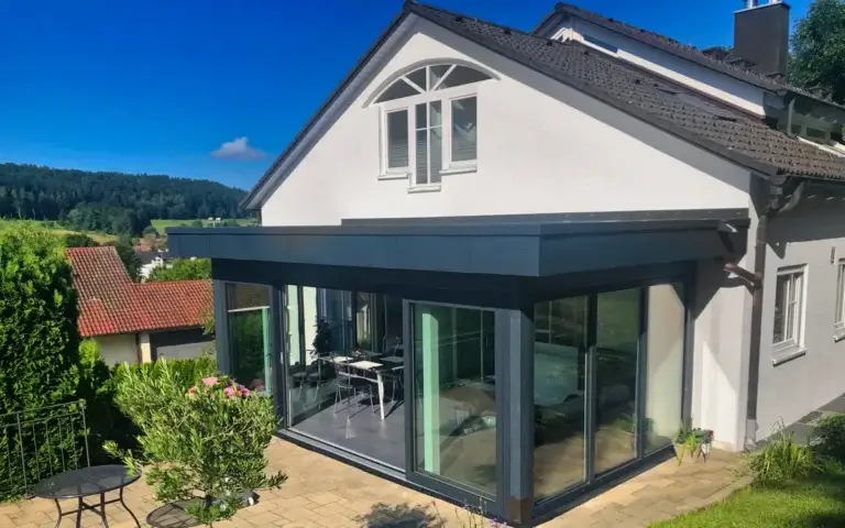 Anbau mit Wintergarten in Onstmettingen: Glasfront an weißem Wohnhaus mit Satteldach