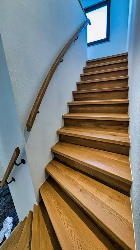 Massivholztreppe mit geschwungenem Handlauf, Detail der Stufen